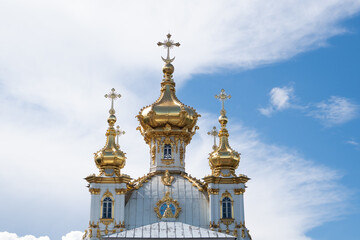 Peterhof Rastrelli Church, the upper part consisting of three domes against the sky with clouds in sunny weather