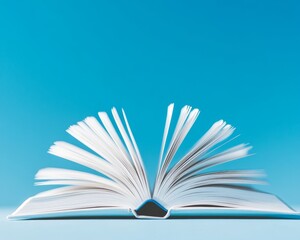 An open book with flying pages against a minimal blue background, symbolizing knowledge and creativity.