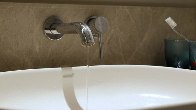 stainless steel sink with water pours from water tap faucet valve without using water, leaky waste of water concept or save water concept assistance in case of plumbing breakdown
