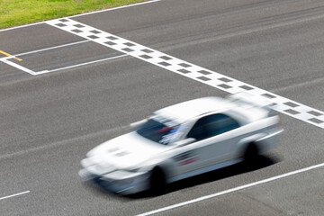 Motion blur race car racing on speed track, Car race on the international circuit race track crossing start and finish line, Race car crossing start and finish line, Target business achieve victory.