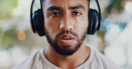 Portrait, headphones and man with fitness, tired and fatigue with sound, listening to music and sweaty. Face, runner or athlete with headset, exhausted or song for motivation, exercise goals or audio