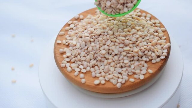 The Stone Grouted Organic Urad Dal Without Skin Vigna mungo, Black Gram, mash kalai, uzhunnu parippu, ulundu paruppu, minapa pappu, Uddu or black, plastic spoon 