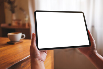 Mockup image of a woman holding digital tablet with blank desktop screen at home