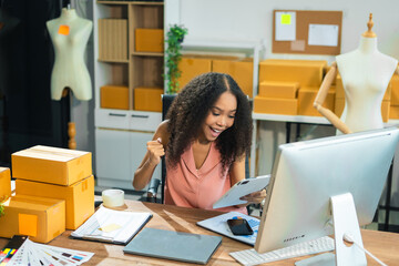 Happy woman smiling at sales success after checking profits from home online store, concept of online commerce and e-commerce.