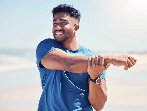 Man, happy and stretching arms by beach for warm up, daily workout routine and fitness for muscle development. Male person, thinking and flexing for physical cardio, training or exercise for health.