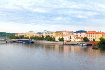 A scenic view of the riverside in Prague. Historic buildings along the water. Vltava River. Prague, Czech Republic.