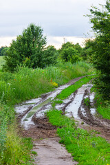 dirty broken rural road with deep tire tracks