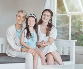 Mother, grandmother and kid with portrait on sofa in home with embrace, bonding and weekend visit with smile. Happy family, women and girl child on couch with relax, support and love in living room