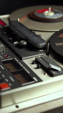 Vertical View, Spinning Reel to Reel Audio Tape of Professional Magnetophone During Playback or Recording, Close Up