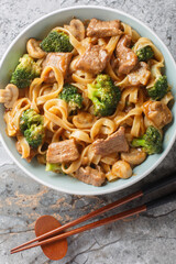 Garlic Beef and Broccoli Noodles with mushrooms for an amazing meal in one closeup on the bowl on the table. Vertical top view from above