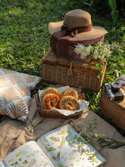 Picnic in garden. Reading books. Breakfast bagels in park. Summer vibes.