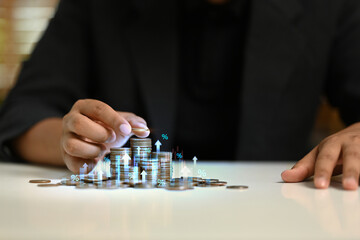 Businessman stacking coins with virtual icons. Income Management and saving money concepts