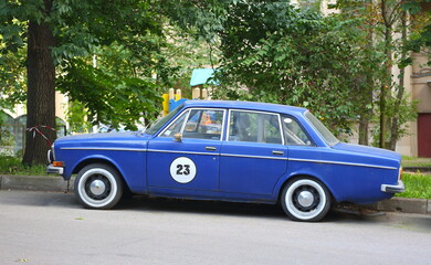 An old blue car is parked in the courtyard of an apartment building, Gromova Street, St. Petersburg, Russia, August 20, 2024