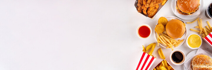 Fast food delivery menu background with various burgers, cheeseburger, nuggets, french fries, fizzy soda drinks. Junk unhealthy fast food, Ultra processed food with low nutrition, high calories value