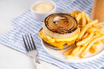 Flying Dutchman Onion Wrapped viral trendy Burger. Homemade cheeseburger with Onion Bun, nuggets and french fries