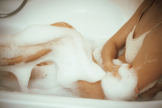 Women's feet in bath foam. View from above. Enjoy and relax in a spa hotel