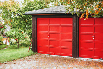 Red garage doors in residential area with house in background