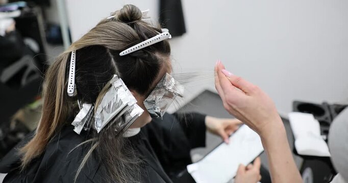 Hair coloring, regrown hair roots on foil, blonde, hairdresser colorist and beauty salon
