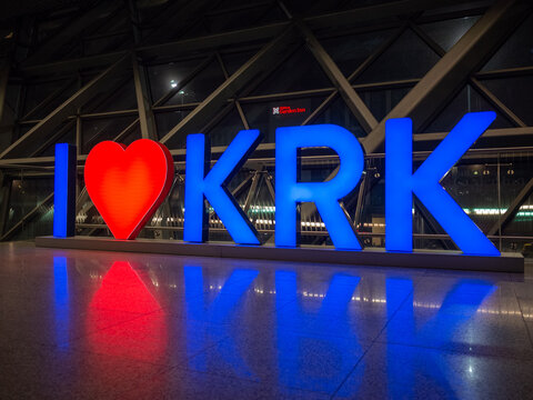 blue and red neoned "I Love Krakow" logo inside krakow airport at night