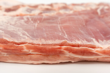 A piece of meat with a white background. The meat is cut in half and has a pinkish color Pork meat isolated on a white background.