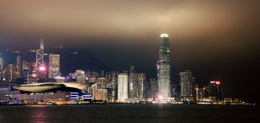 Fototapeta premium Night panorama showcasing the vibrant skyline of Hong Kong with illuminated skyscrapers and a serene harbor view