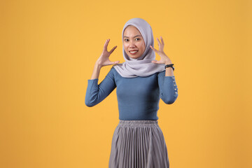 angry asian indonesian muslim woman wearing hijab on isolated yellow background