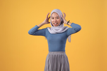 Naklejka premium angry asian indonesian muslim woman wearing hijab on isolated yellow background