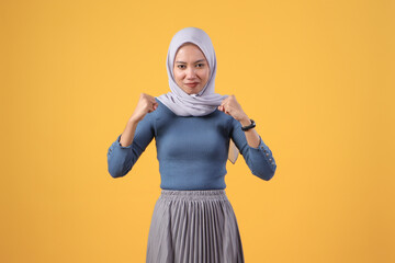 angry asian indonesian muslim woman wearing hijab on isolated yellow background
