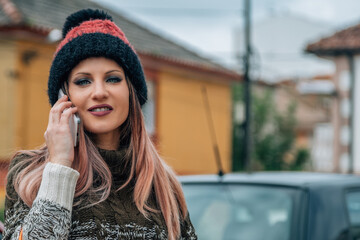 young woman with shopping bags and mobile phone on the street