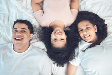 Mom, dad and kid in portrait on bed with smile, love and relax in morning together from above. Mother, father and girl child bonding in bedroom with happy family, fun and care on weekend in home