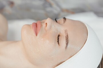 The cosmetologist applies transparent gel on the face of young female patient. Beauty procedure in cosmetology clinic. Eyes mask woman face cosmetic concept beauty portraitMake-up texture skincare pro