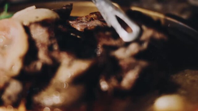 Closeup of grill with deliciouse seafood, shrimp, crab, mussle, pork sausage and vegetable on wood table with chopsticks in BBQ grill restaurant from thailand