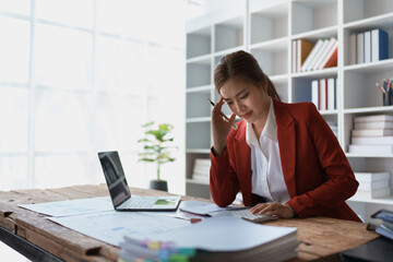 woman meticulously plans a finance audit, using a computer and calculator to review budget documents and ensure accuracy