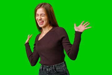 Young Woman in Brown Sweater Laughing and Gesturing Against a Green Screen