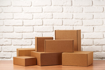 Stacked Cardboard Boxes Against A White Brick Wall