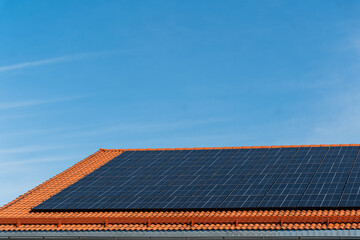 bunch of solar panels on roof during sunny day with blue sky