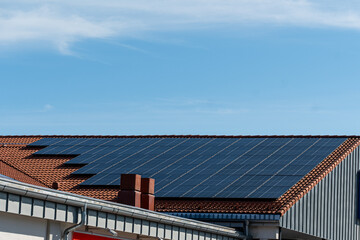 bunch of solar panels on roof during sunny day with blue sky