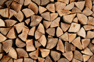 Wood for The Fire. Background of stacked chopped wood logs. Pile of wood logs ready for winter. Wooden stumps, firewood stacked in heap.