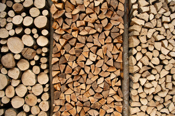 Wood for The Fire. Background of stacked chopped wood logs. Pile of wood logs ready for winter. Wooden stumps, firewood stacked in heap.