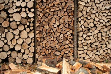 Wood for The Fire. Background of stacked chopped wood logs. Pile of wood logs ready for winter. Wooden stumps, firewood stacked in heap.