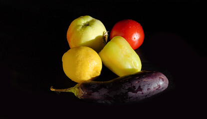 Ripe Yellow Lemon, Apple, Tomato, Sweet Pepper, and Eggplant on a Black Background