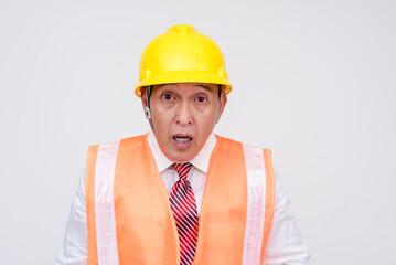 A construction project manager or engineer in a safety helmet and vest looking shocked and taken aback by an emergency. Isolated on a white background.