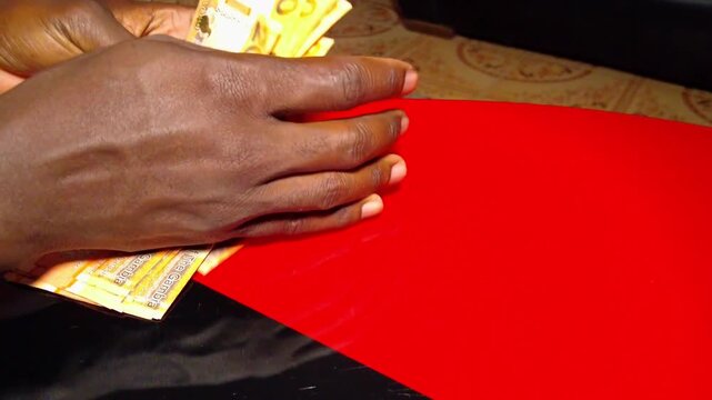 Stacking new 200 Dalasi notes on a glass table close-up