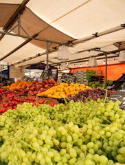 Market stall with white grapes and other fruits. Offered at the weekly market in Rotterdam. Healthy food, ripe, ready-to-eat, trader, price tag, food.