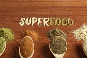 Word Superfood and different healthy powders on wooden table