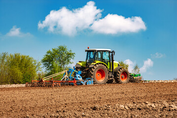 Tractor with harrow and cultivator on the field during tillage