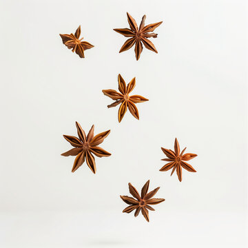 Floating star anise flakes and pieces on white background