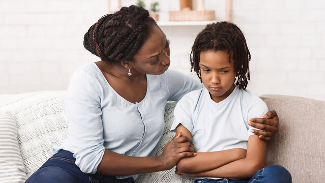 African Mother Apologizing To Her Offended Daughter After Quarrel On Sofa At Home