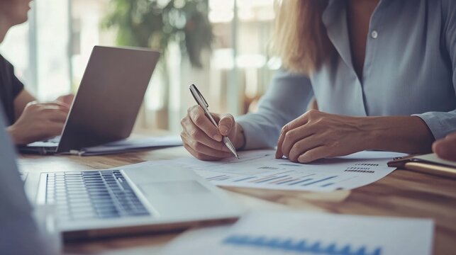 A professional financial advisor sitting at a desk with a laptop, discussing investment options with a client, light solid color background