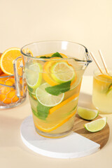 Fototapeta premium Freshly made lemonade with mint in jug and glass on beige background